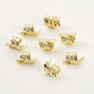 Macro detail of 14k gold plated feather charms showing intricate vein textures for DIY crafts