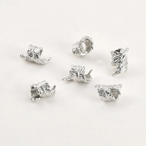 Detailed view of silver feather charms showing fine engraved textures for DIY jewelry