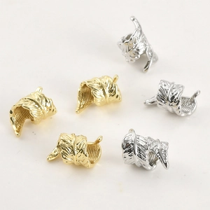 Macro view of 14k gold and silver feather charms with detailed texture for DIY jewelry