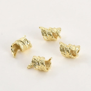 Macro shot of 14k gold-plated feather charms with detailed leaf texture for DIY jewelry