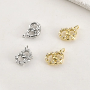 Détail des breloques cœur bretzel plaquées or 14k et argent avec incrustation zircon