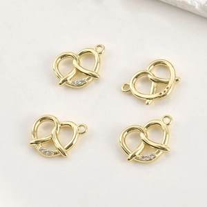 Détail de quatre pendentifs cœur plaqués or 14 carats avec zircons pour bijoux DIY