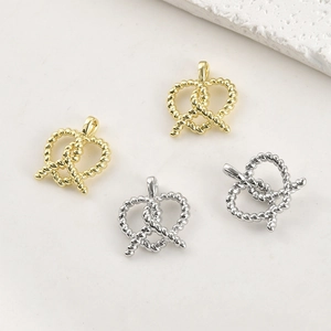 Détail de pendentifs cœur bretzel en or 14k et argent avec texture de corde tordue