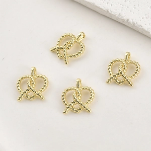 Gros plan de pendentifs bretzel en cœur plaqués or 14k avec texture spirale pour bijoux DIY