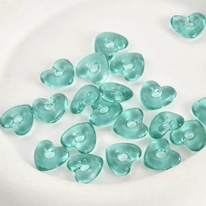 Makro-Detail von blauen, durchscheinenden herzförmigen Glasperlen für DIY-Schmuck