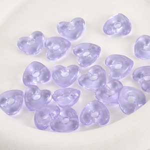 Makroaufnahme von lila transparenten Herzperlen für DIY-Schmuck mit Mittelloch-Detail