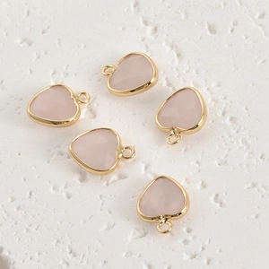 Detailed view of pink crystal heart pendants with gold plated edges for DIY jewelry making