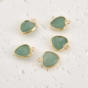 Detailed view of five faceted green natural stone heart pendants with gold plated edges