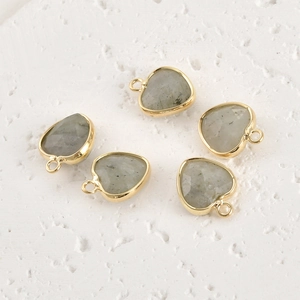 Detail of five faceted heart-shaped grey gemstone pendants with gold-plated edges