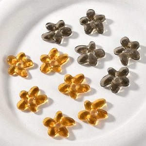 Detail of amber and smoke grey glass flower beads with center holes for DIY jewelry
