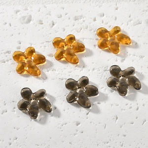 Close-up of translucent five-petal flower beads in amber and smoke grey for jewelry DIY