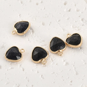 Macro shot of five blue sandstone heart pendants with faceted surface and gold edges