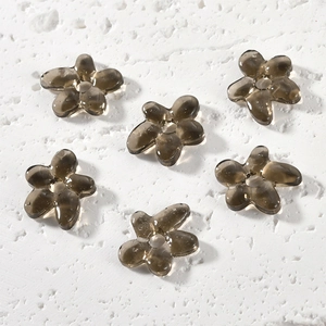 Macro shot of six translucent smoky gray glass flower beads for DIY jewelry making