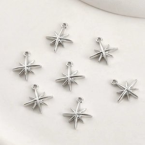 Close-up of polished 14k gold starburst pendants with sparkling zircon on a ceramic tray