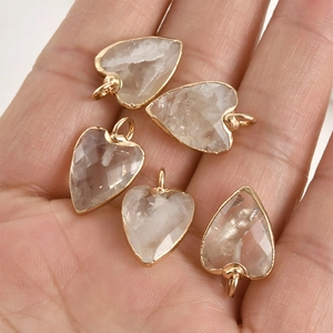 Lot de cinq pendentifs en cristal en forme de cœur avec bord doré présentés dans la main