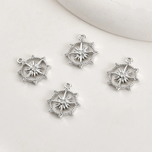 Macro detail of silver starburst pendants with white zircons for DIY jewelry making