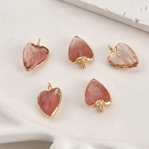 Détail macro de cinq pendentifs cœurs en cristal rose avec bordure élégante plaquée or
