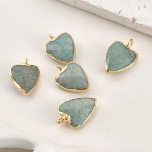 Détail de pendentifs cœur en amazonite avec bordure dorée pour la création de bijoux