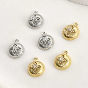 Macro detail of 14k gold plated starburst charms with zircon for DIY jewelry making