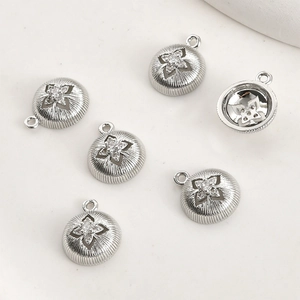 Detailed macro view of six silver starburst pendants with clear cubic zirconia stones