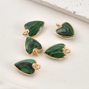 Vue détaillée des pendentifs malachite en forme de cœur avec bordure en métal doré