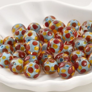 Nahaufnahme von Lampwork-Glasperlen mit bunten Punkten für DIY-Schmuckherstellung