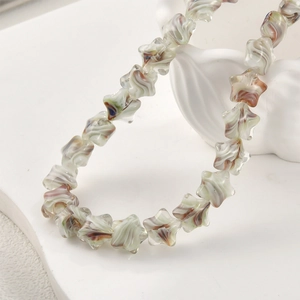Makroaufnahme handgefertigter Glasperlen in Sternform mit Wirbelmuster für DIY Schmuck