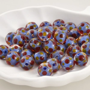 Makroaufnahme von hellblauen Glasperlen mit roten und gelben Punkten für DIY-Schmuck