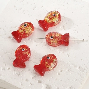 Macro shot of red handmade fish glass beads with gold foil for DIY jewelry making