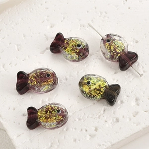 Macro detail of purple goldfish glass beads with gold foil for DIY jewelry making