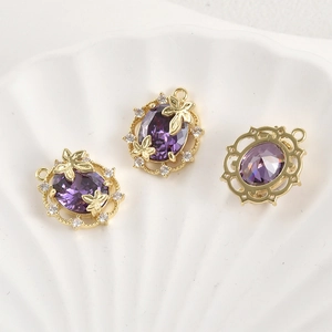 Close-up of 14k gold-plated oval pendant with purple zircon and delicate butterfly detail