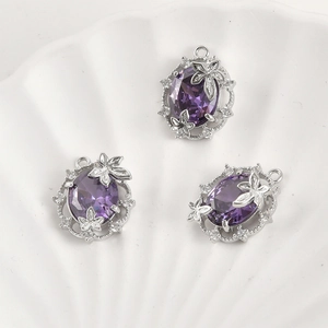Macro view of purple oval crystal pendants with silver floral leaf frame for DIY jewelry