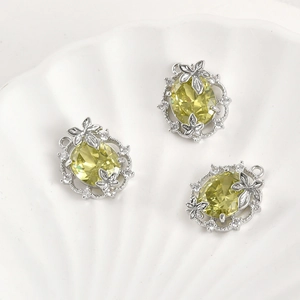 Macro detail of 14k gold plated oval olive green zircon leaf pendants for jewelry making