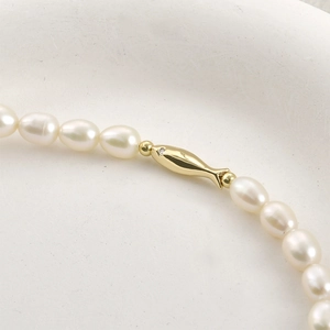 Baroque pearl necklace featuring a 14k gold-plated fish charm with delicate diamond accent