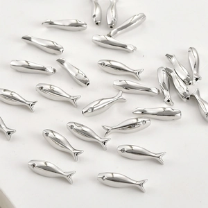 Macro detail of polished silver fish-shaped spacer beads for DIY jewelry making and crafts