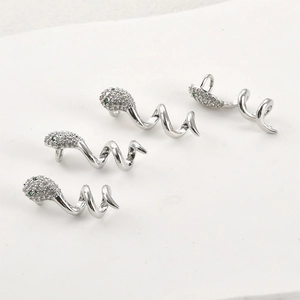 Detailed macro view of 14k plated snake charm with white cubic zirconia and green gem eyes
