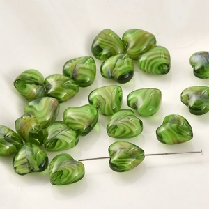 Macro detail van 12mm hartvormige glaskralen met groene spiraalstructuur voor DIY
