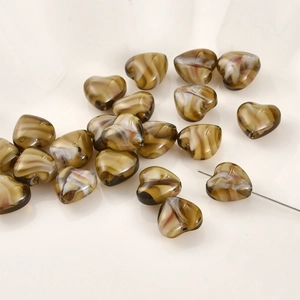 Macro-detail van hartkralen met bruin marmerpatroon en gaatjes voor het maken van sieraden
