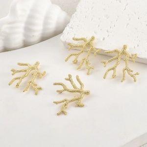 Detail of four 14k gold plated coral branch charms for jewelry making on stone setup