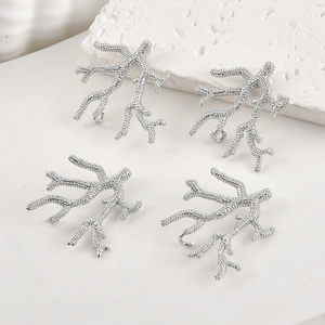 Detailed view of four silver coral branch charms with textured matte finish for DIY jewelry