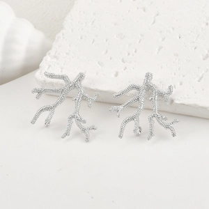 Macro detail of silver coral branch earrings with matte texture and DIY hanging loop