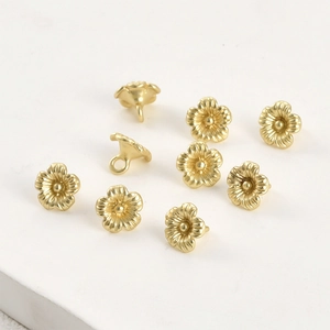 Dettaglio dei ciondoli a fiore a cinque petali placcati oro 14k con finitura opaca