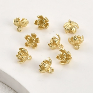 Dettaglio di ciondoli a fiore placcati in oro opaco con ganci per creazione gioielli DIY