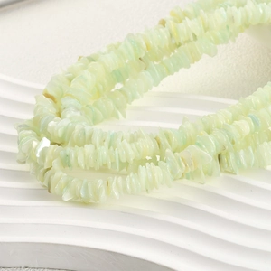 Primer plano de collar multihilo de conchas naturales verde menta en soporte blanco