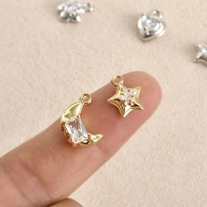 Handheld view of 14k gold plated moon and star charms with zircon for DIY jewelry