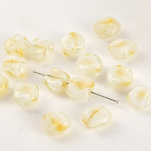 Macro detail of cream and yellow swirl patterned glass beads for DIY jewelry making