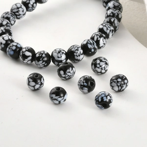 Macro detail of retro black glass beads with white snowflake pattern for DIY jewelry