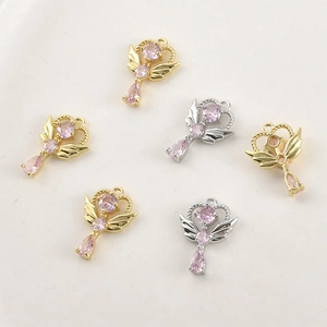 Détail macro de pendentifs cœur ailes d'ange plaqués or 14 carats avec cristaux roses