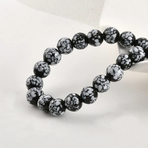 Close-up of black and white snowflake pattern glass beads for DIY jewelry making