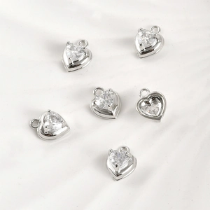 Detail of six heart-shaped silver charms with clear zircon in 4-prong setting for DIY jewelry